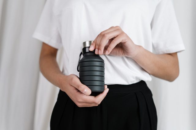 person holding reusable water bottle